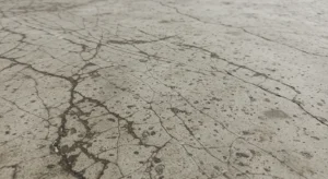 Concrete floor showing visible cracking and moisture damage problems